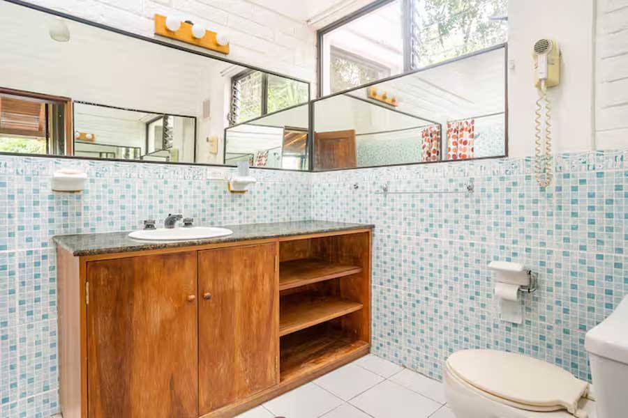 Baño con mueble de madera y mosaico claro